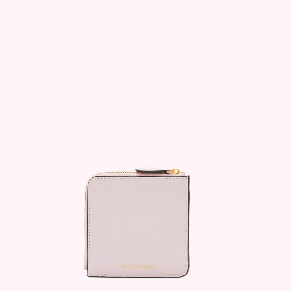 Pale pink leather zip-around wallet by Lulu Guinness, shown against a white background.
