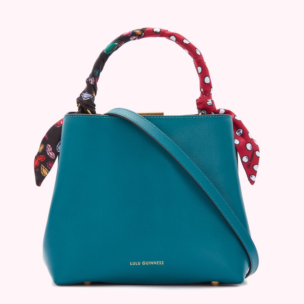 Teal Lulu Guinness handbag with a patterned scarf handle.
