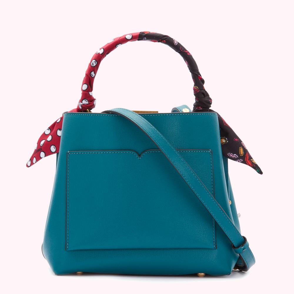 Teal leather handbag with a patterned scarf wrapped around the handle.
