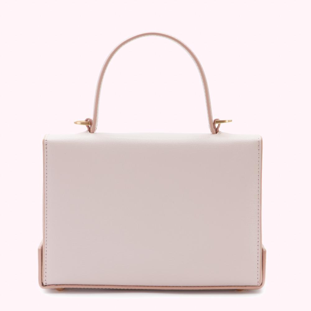 A pale pink rectangular handbag with a single top handle and gold-toned hardware.

