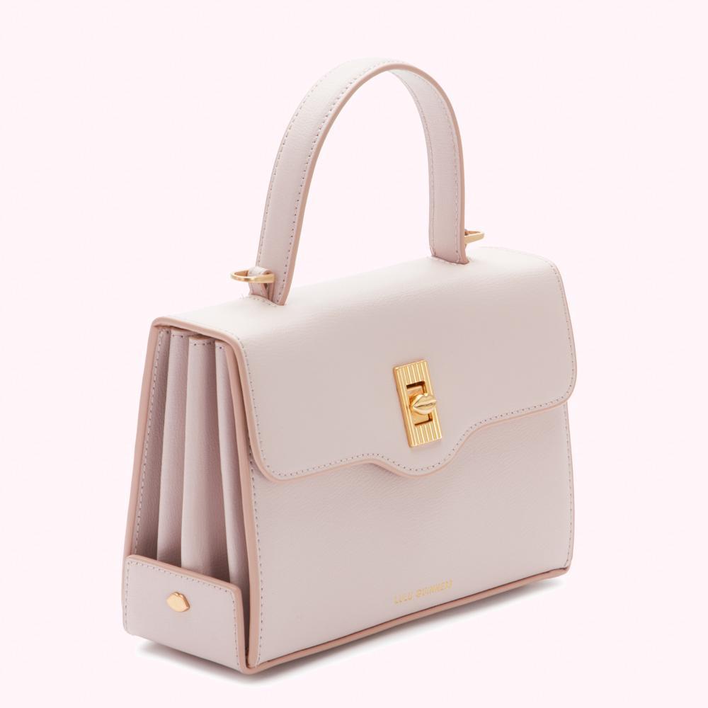 A pale pink leather handbag with gold hardware.