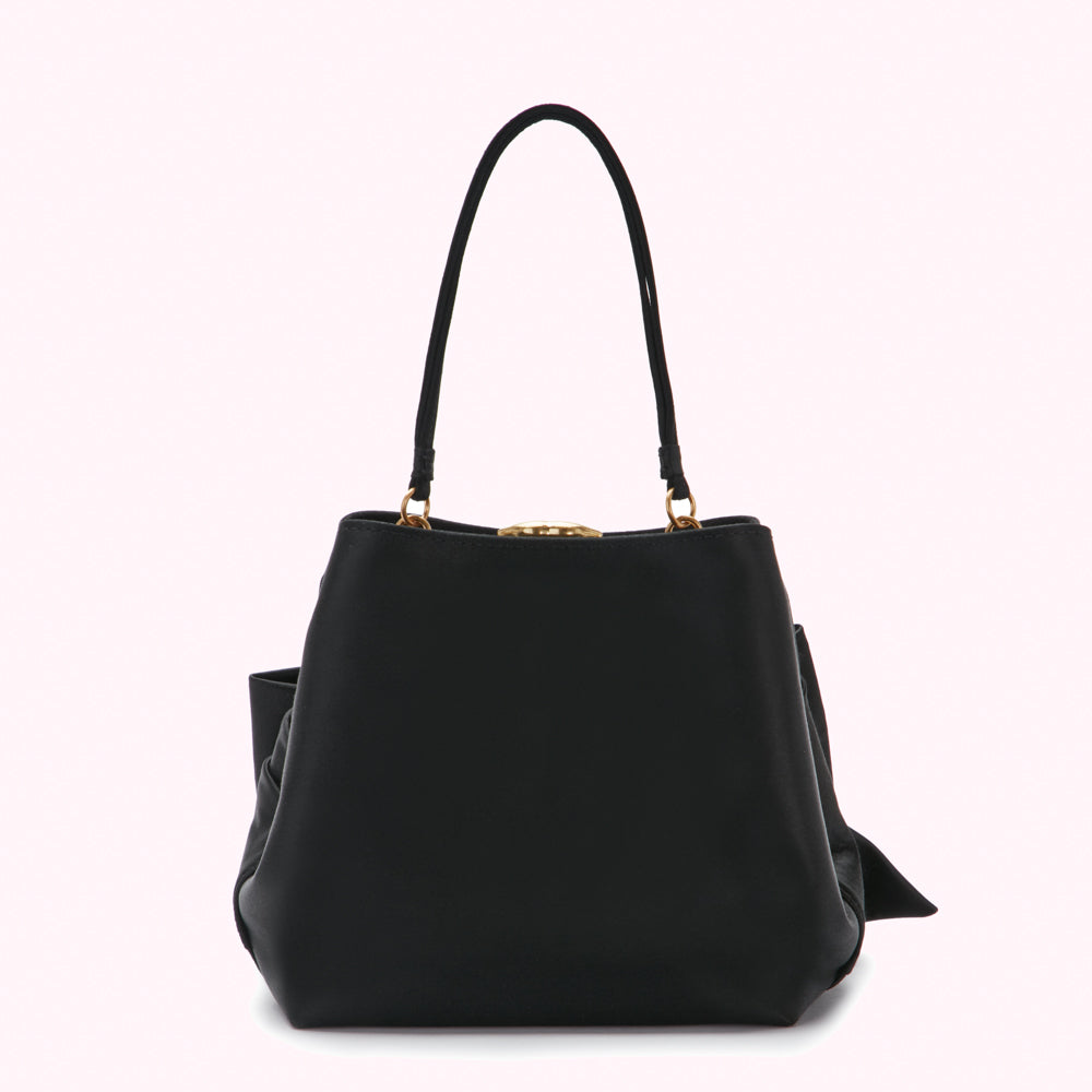 Black leather handbag with gold clasp and bow detail.
