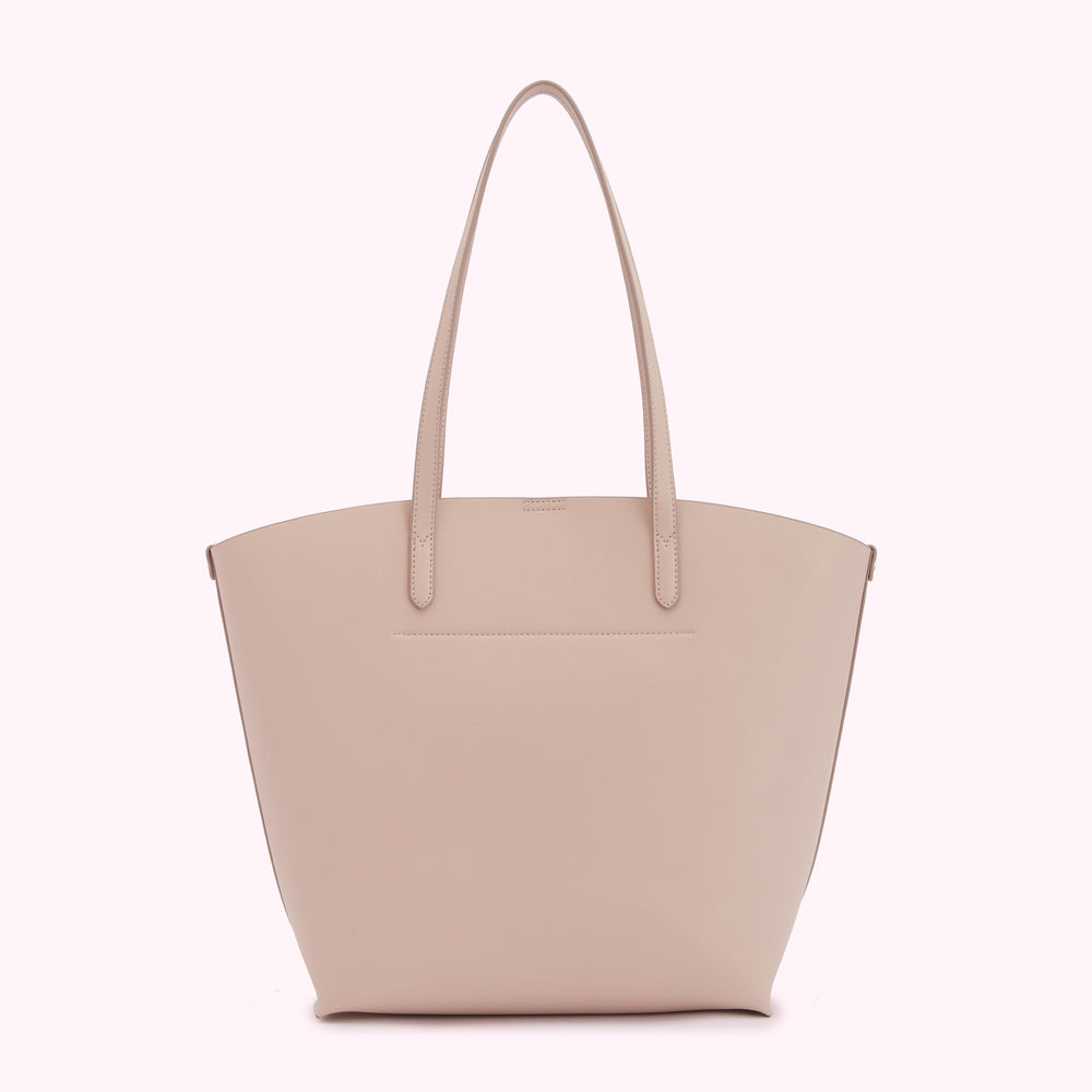 A pale pink tote bag on a white background.