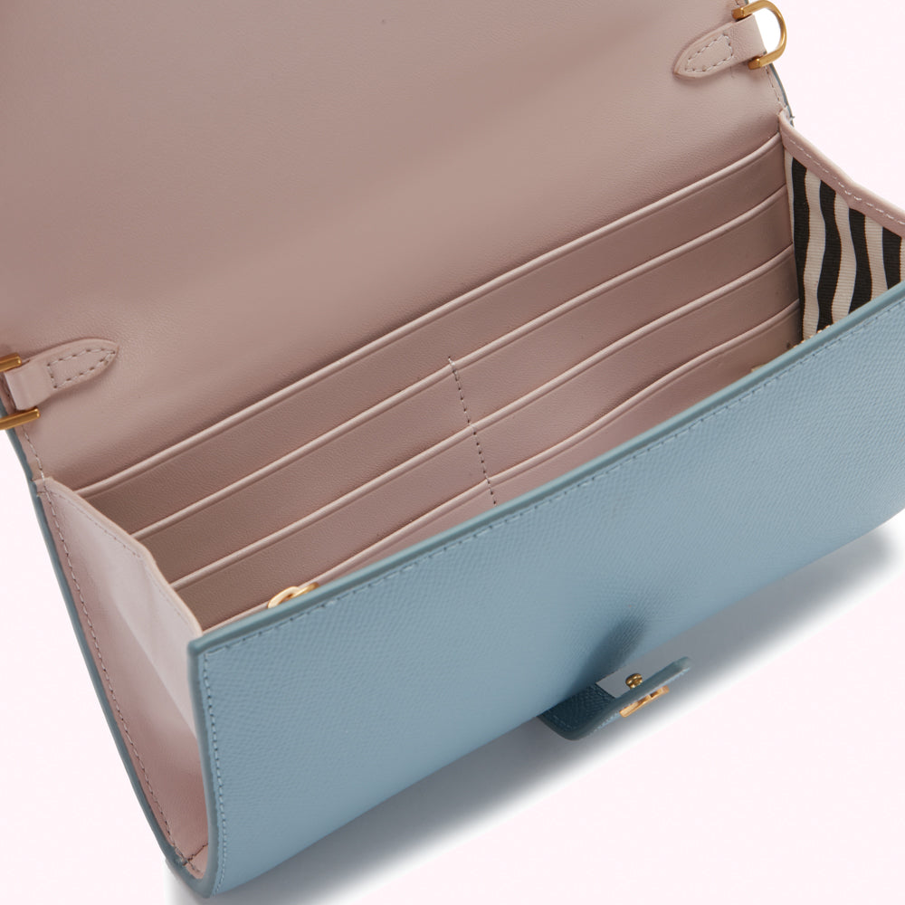 Open light blue leather wallet with blush pink interior and multiple card slots.
