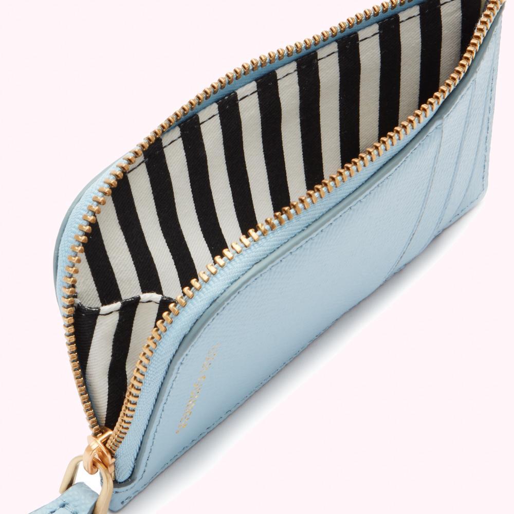Light blue leather cardholder open to reveal a black and white striped interior.
