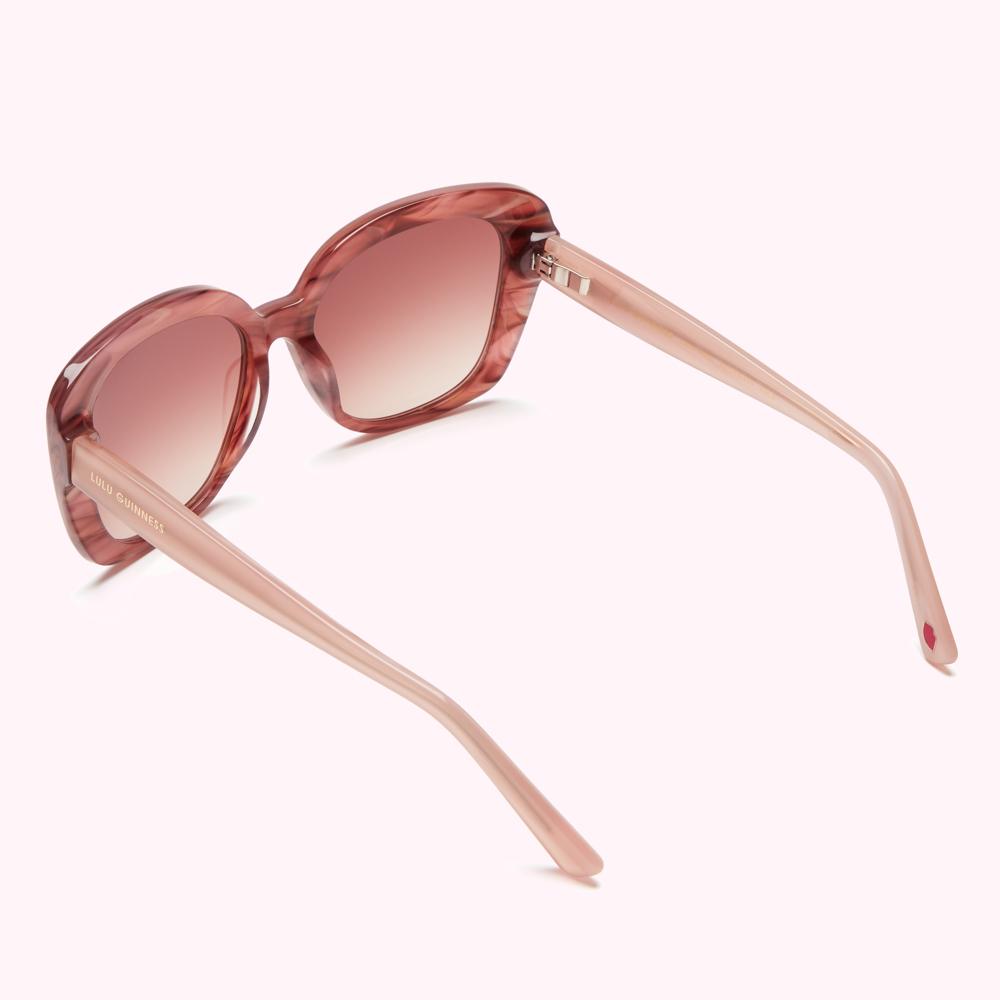 Pink Lulu Guinness sunglasses with a tortoiseshell pattern on a white background.
