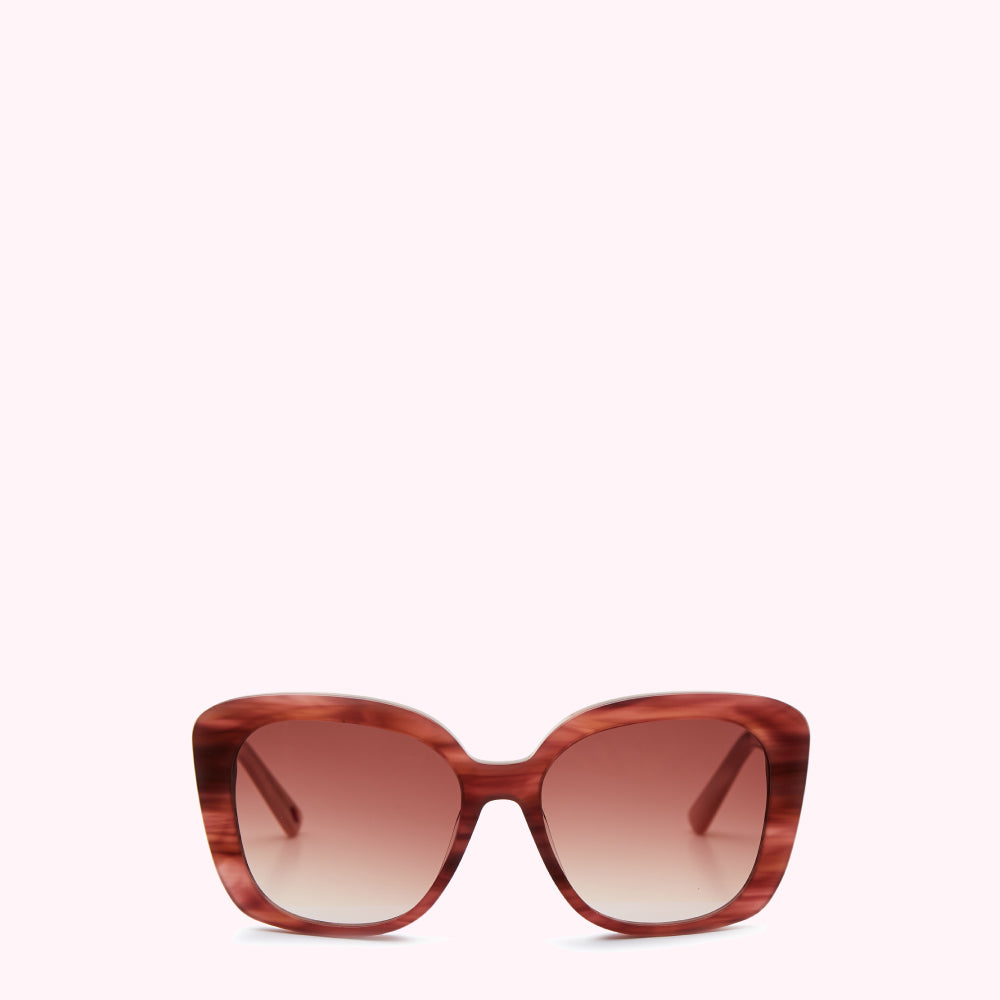 Brown and pink sunglasses with a gradient brown lens against a white background.
