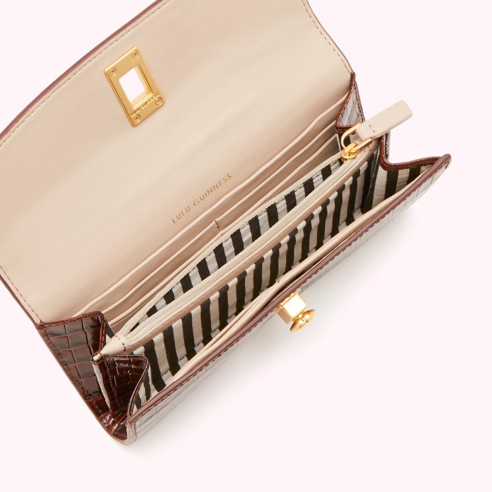 Open brown Lulu Guinness crocodile-embossed leather wallet with beige interior and gold hardware.
