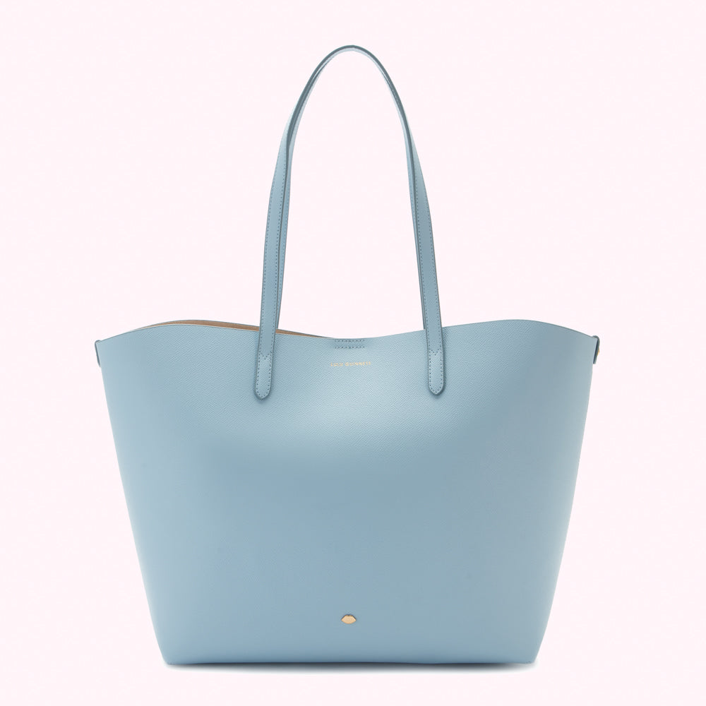 Light blue tote bag with light brown handles and gold logo.
