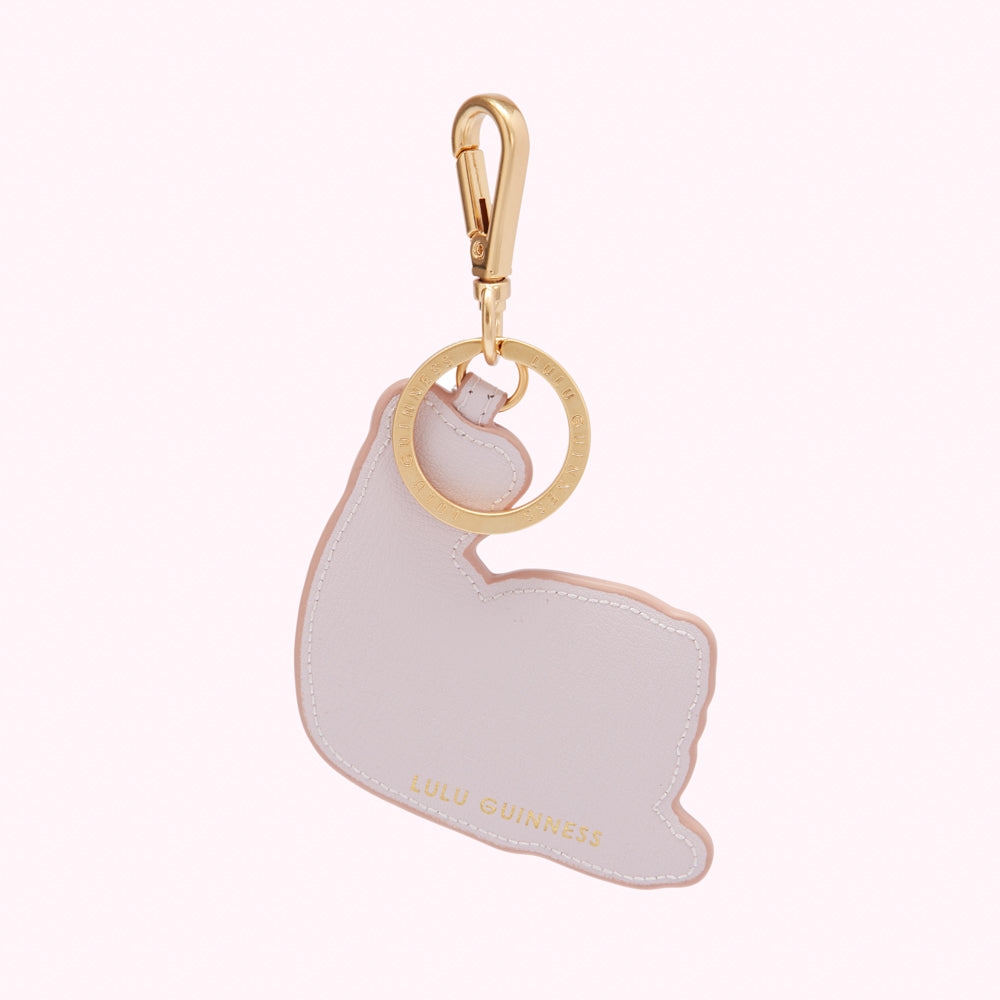 A pale pink leather Lulu Guinness keyring in the shape of a bicep. The keyring has a gold clasp and ring with the brand name engraved.

