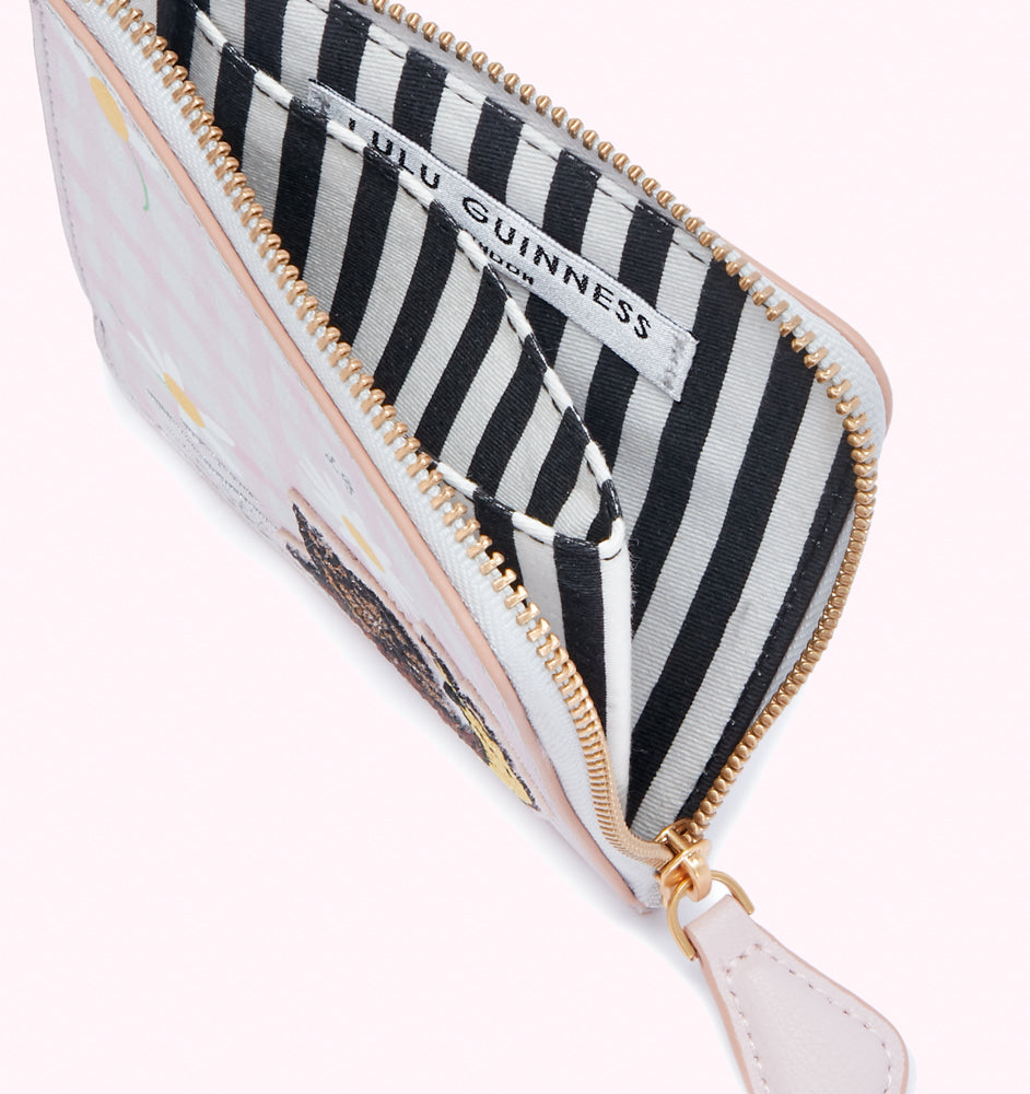 Open Lulu Guinness purse with a pink daisy print and black and white striped interior.