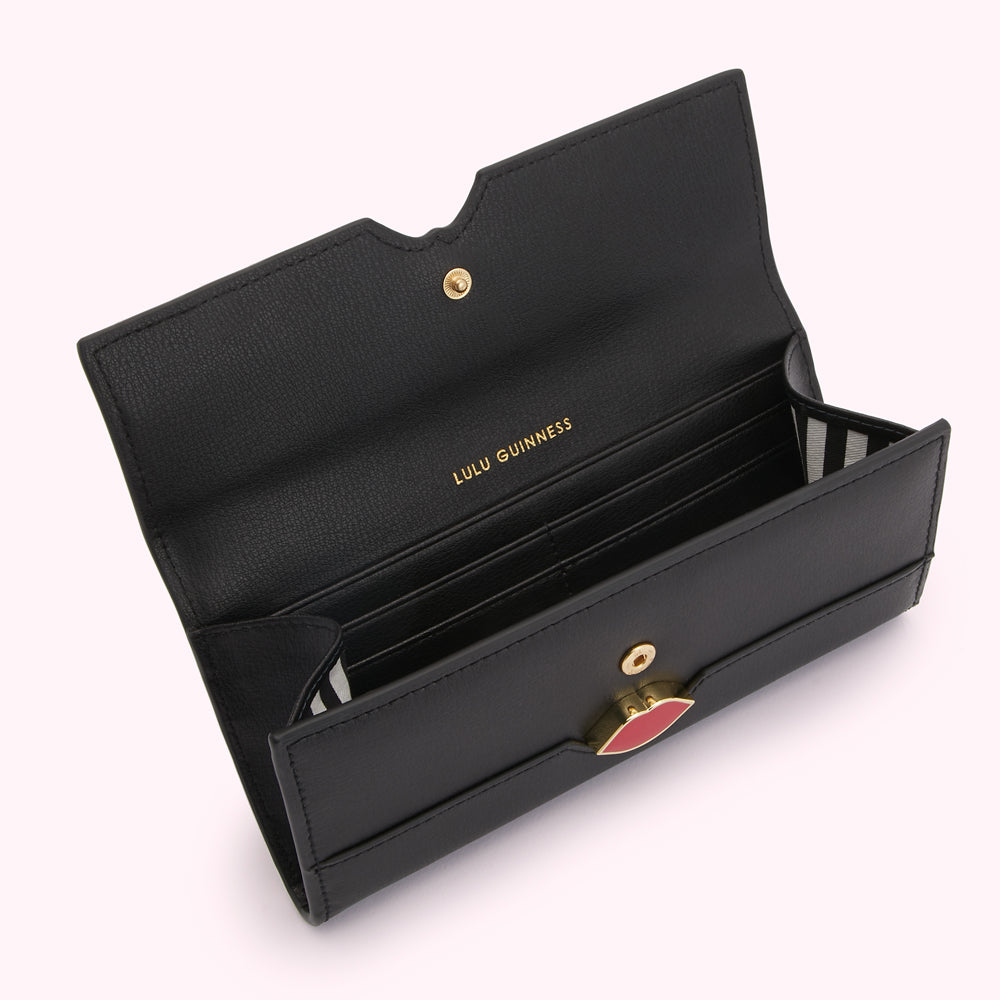 Open black Lulu Guinness wallet with red lip detail.
