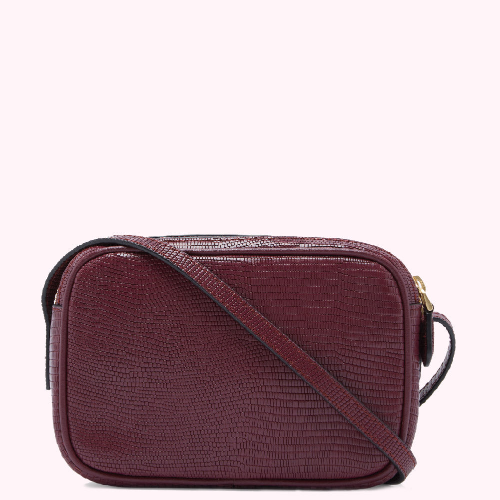 Burgundy crossbody bag with a textured leather-like finish.
