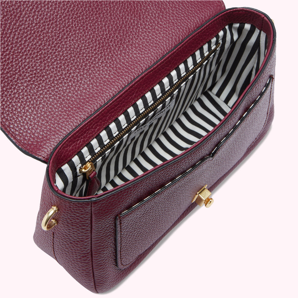 Burgundy pebble leather satchel with black and white striped interior lining and gold-toned hardware.