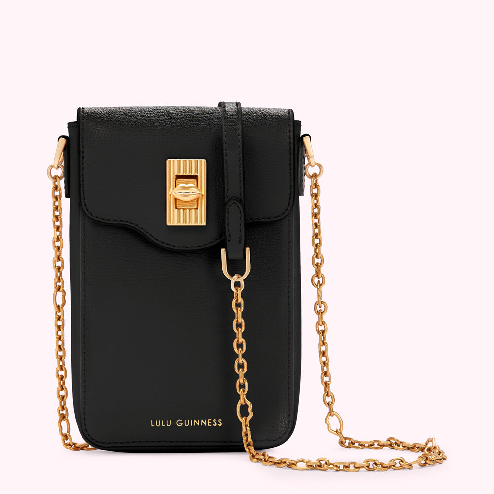 Black Lulu Guinness crossbody bag with gold chain strap and lip-shaped clasp.

