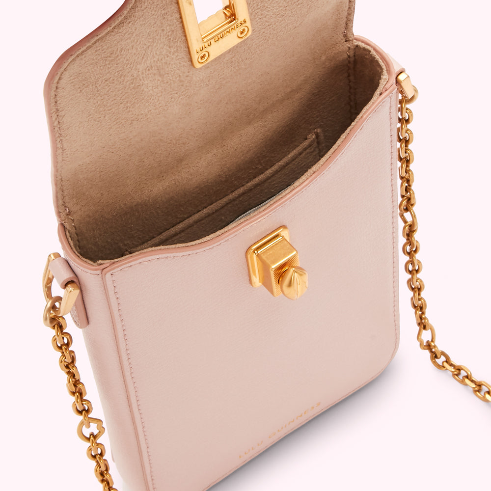 A blush pink Lulu Guinness crossbody bag with a gold chain strap and clasp. The bag is open, showing a beige interior.
