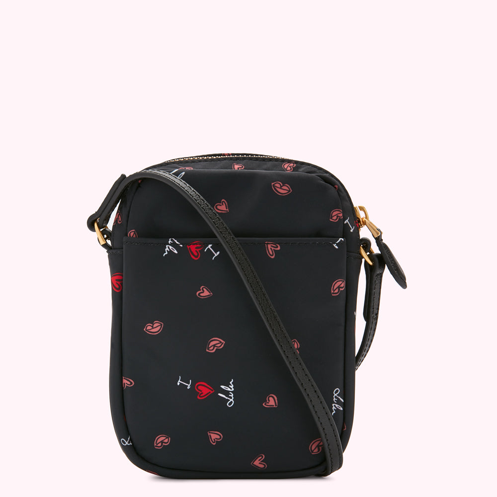 Black crossbody bag with a repeating pattern of red lips and hearts and the text "I love lulu" printed on it.