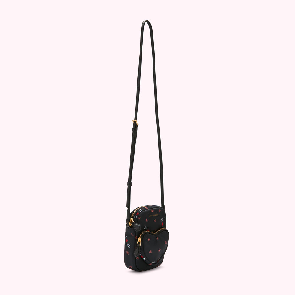 Black crossbody bag with a heart-shaped pocket and a red and white heart pattern.
