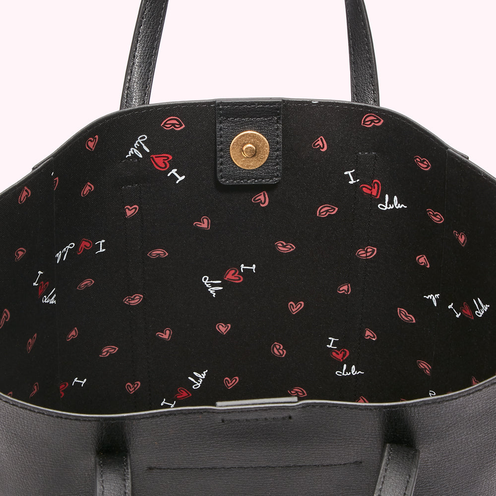 Inside of a black tote bag with a black and red print featuring hearts and lips. The print also includes the text "I love Lulu".