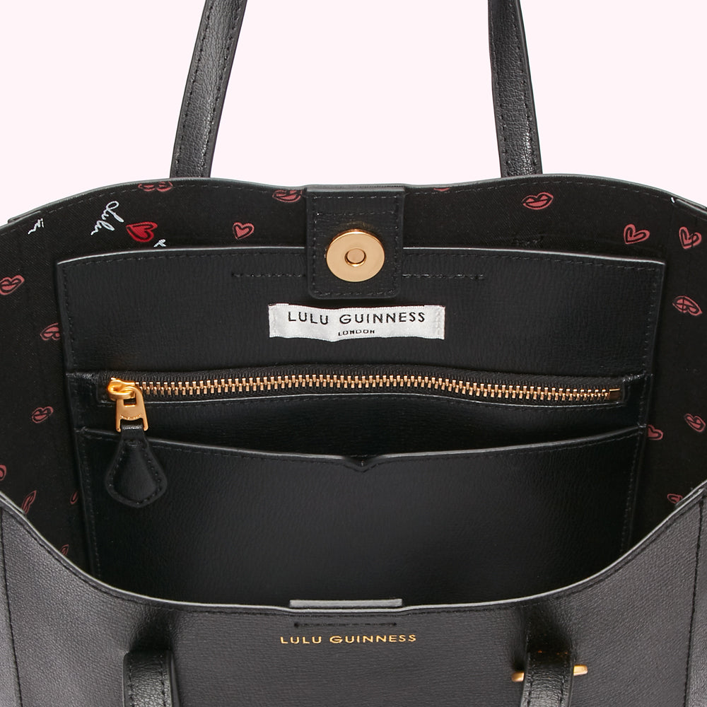 Inside of a black Lulu Guinness tote bag with a printed lining.