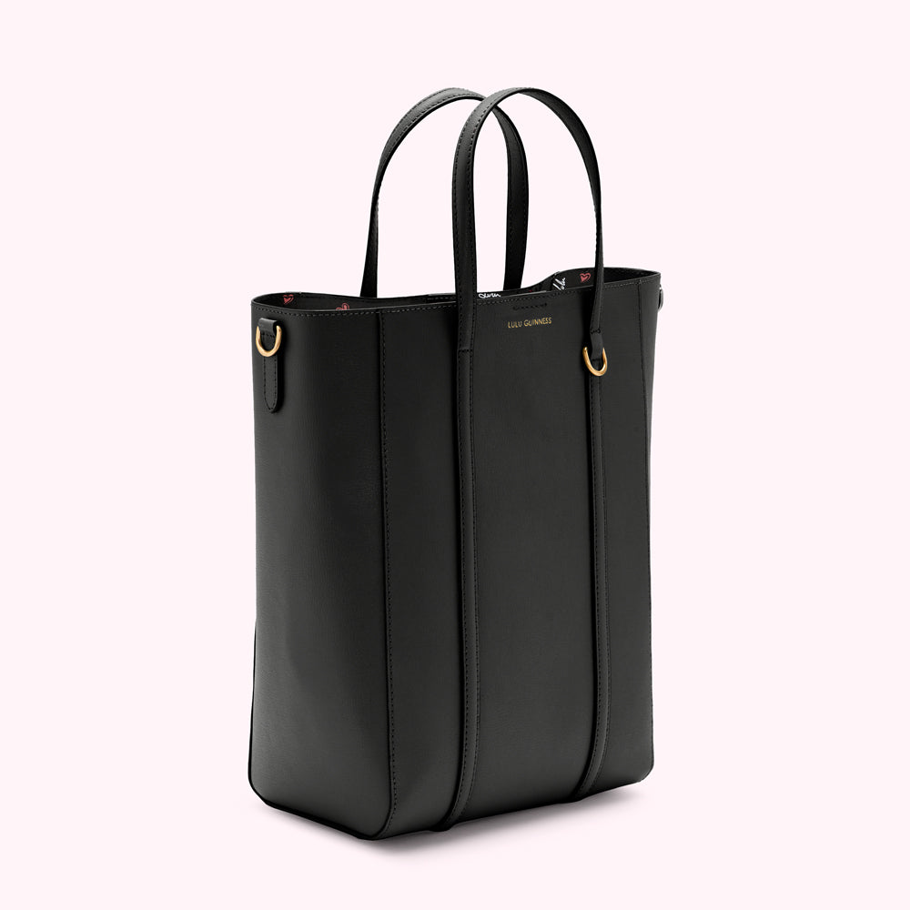 Black Lulu Guinness tote bag with gold hardware, shown from the side against a white background.
