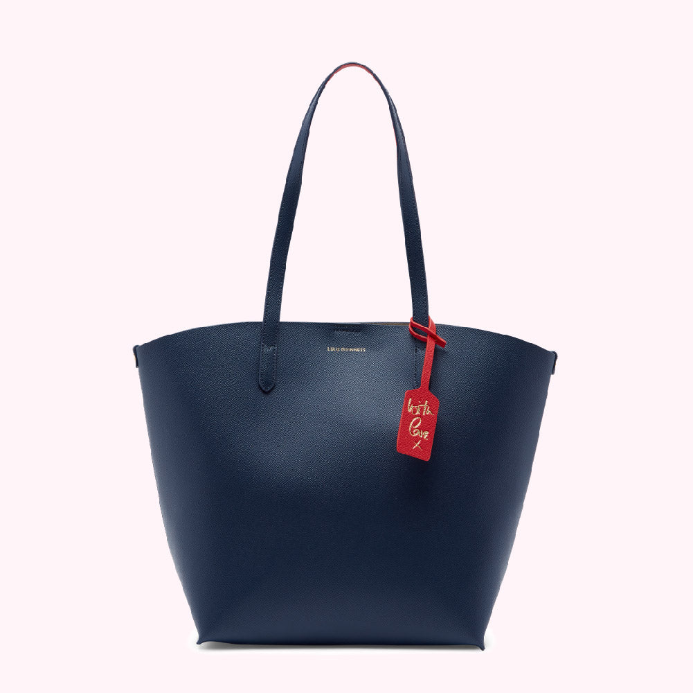 Navy blue tote bag with red leather accents and a red tag that says "With Love" in gold lettering.