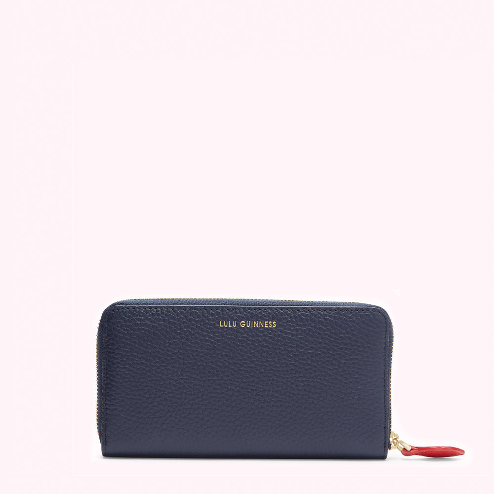 Navy blue Lulu Guinness zip-around wallet against a white background.
