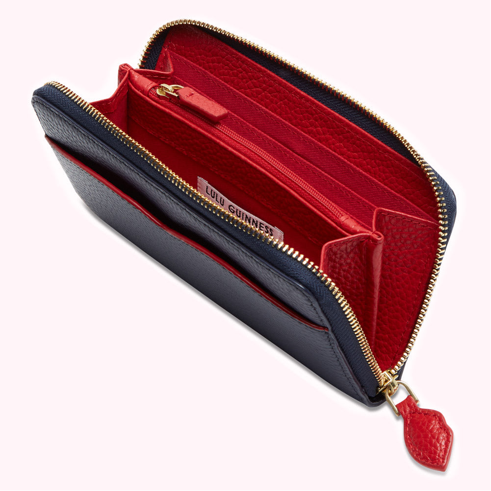 Open navy blue and red Lulu Guinness zip-around wallet with gold zipper.
