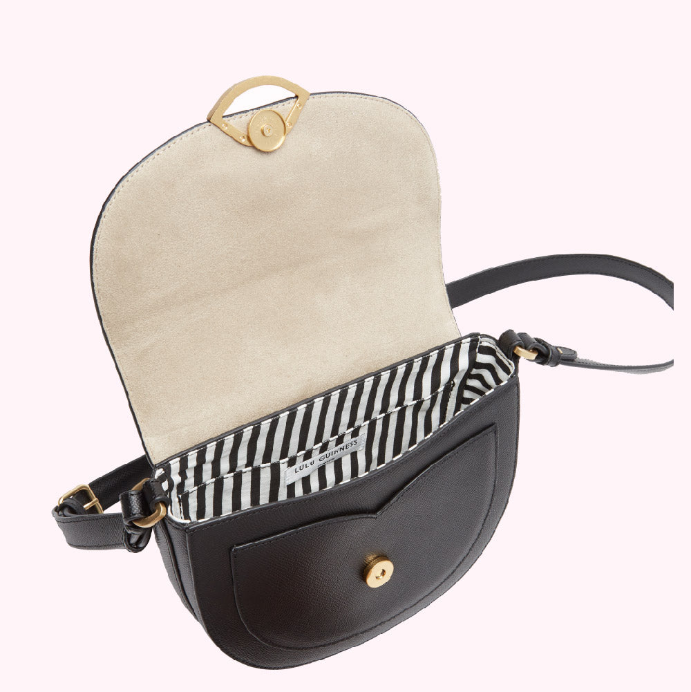 Open black Lulu Guinness crossbody bag with beige interior and black and white striped lining.
