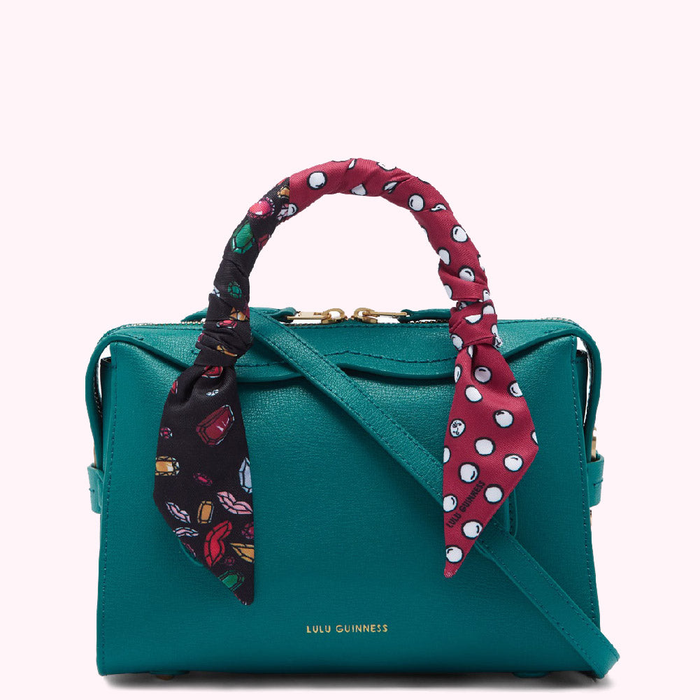 Teal Lulu Guinness handbag with a patterned scarf handle.
