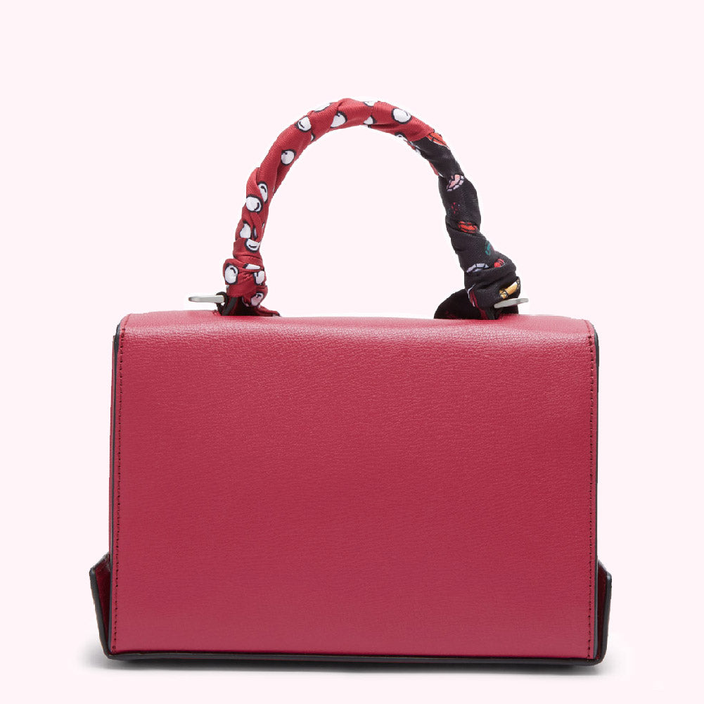 Crimson red handbag with a patterned fabric handle.
