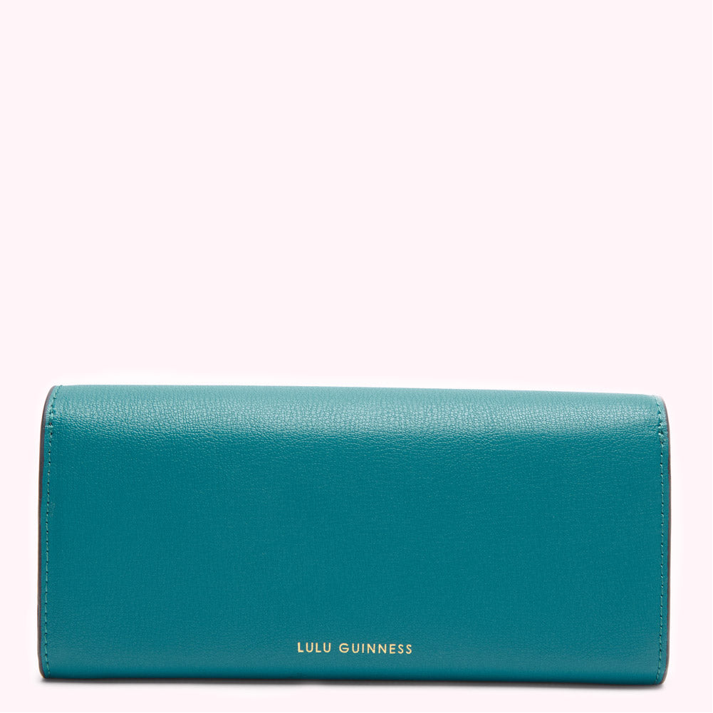 Teal Lulu Guinness wallet on white background.

