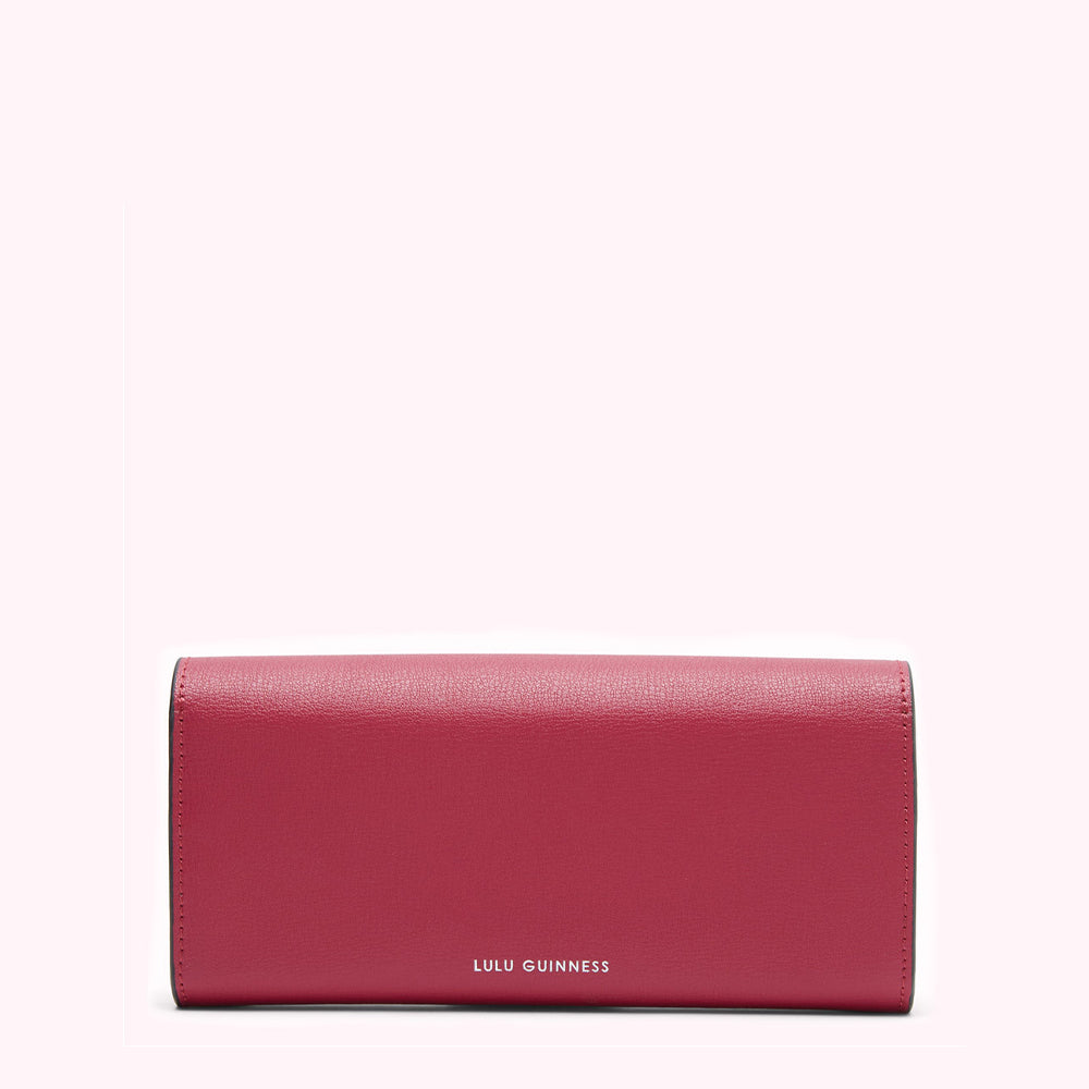 Crimson Lulu Guinness wallet on white background.
