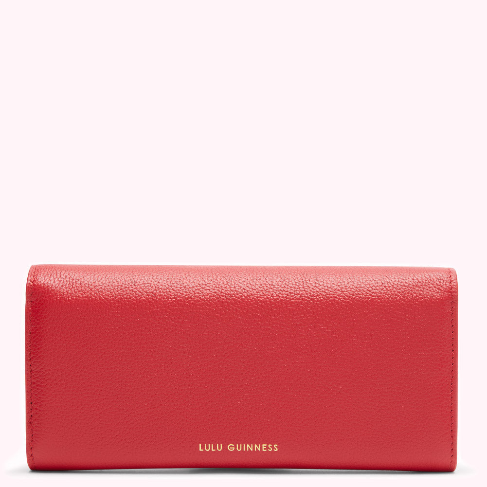 Red leather Lulu Guinness wallet on a white background.