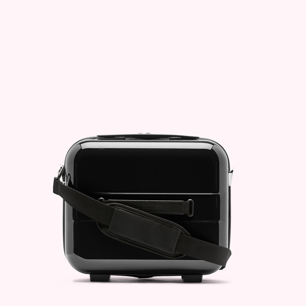 Black polycarbonate carry-on vanity case with a black shoulder strap against a white background.
