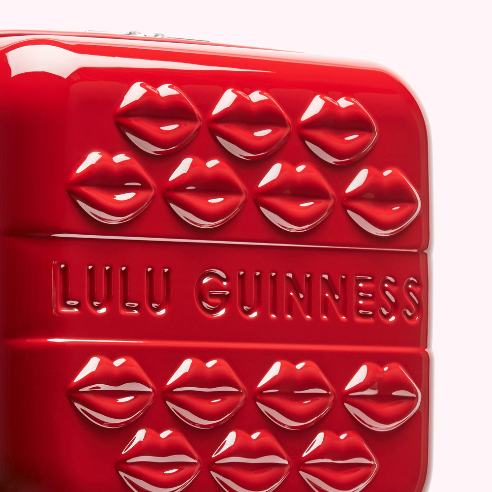 Red Lulu Guinness suitcase with embossed lips.