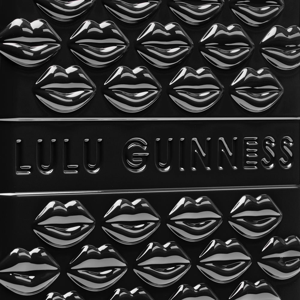 Close-up of a black Lulu Guinness item with embossed lips and logo.