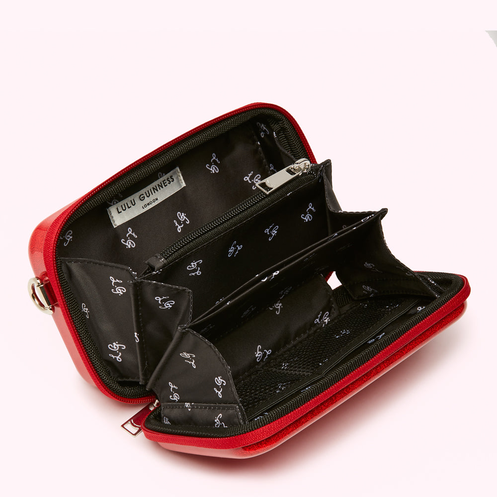 Open red Lulu Guinness purse showing multiple compartments and black interior with the brand's logo.
