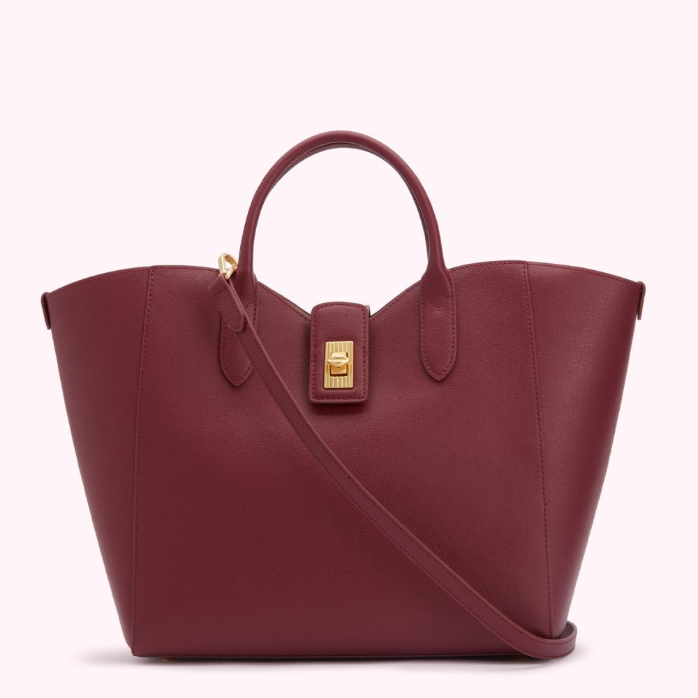 Burgundy leather tote bag with gold clasp and shoulder strap, on a white background.
