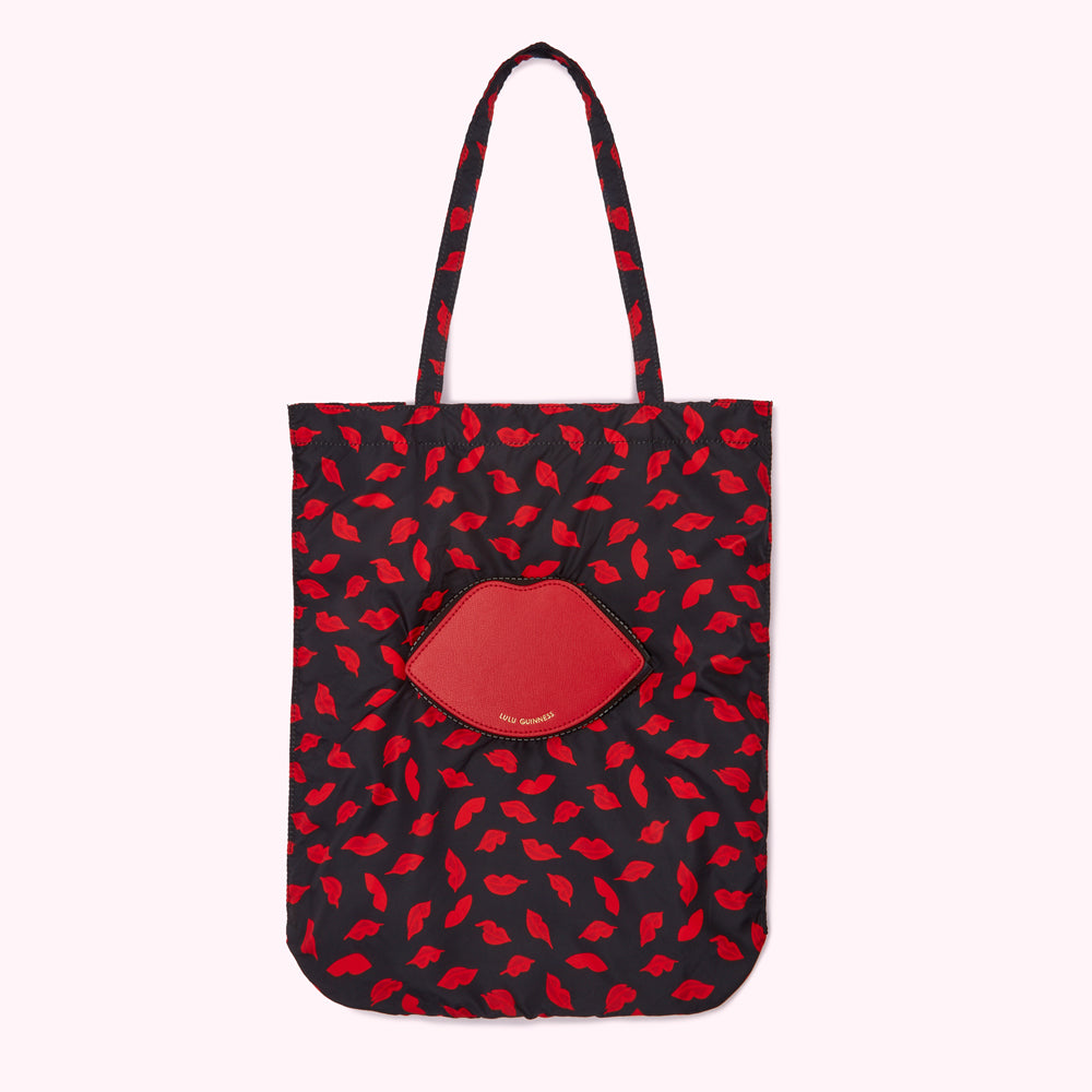 Black tote bag with red lips print and a red lip-shaped pocket.