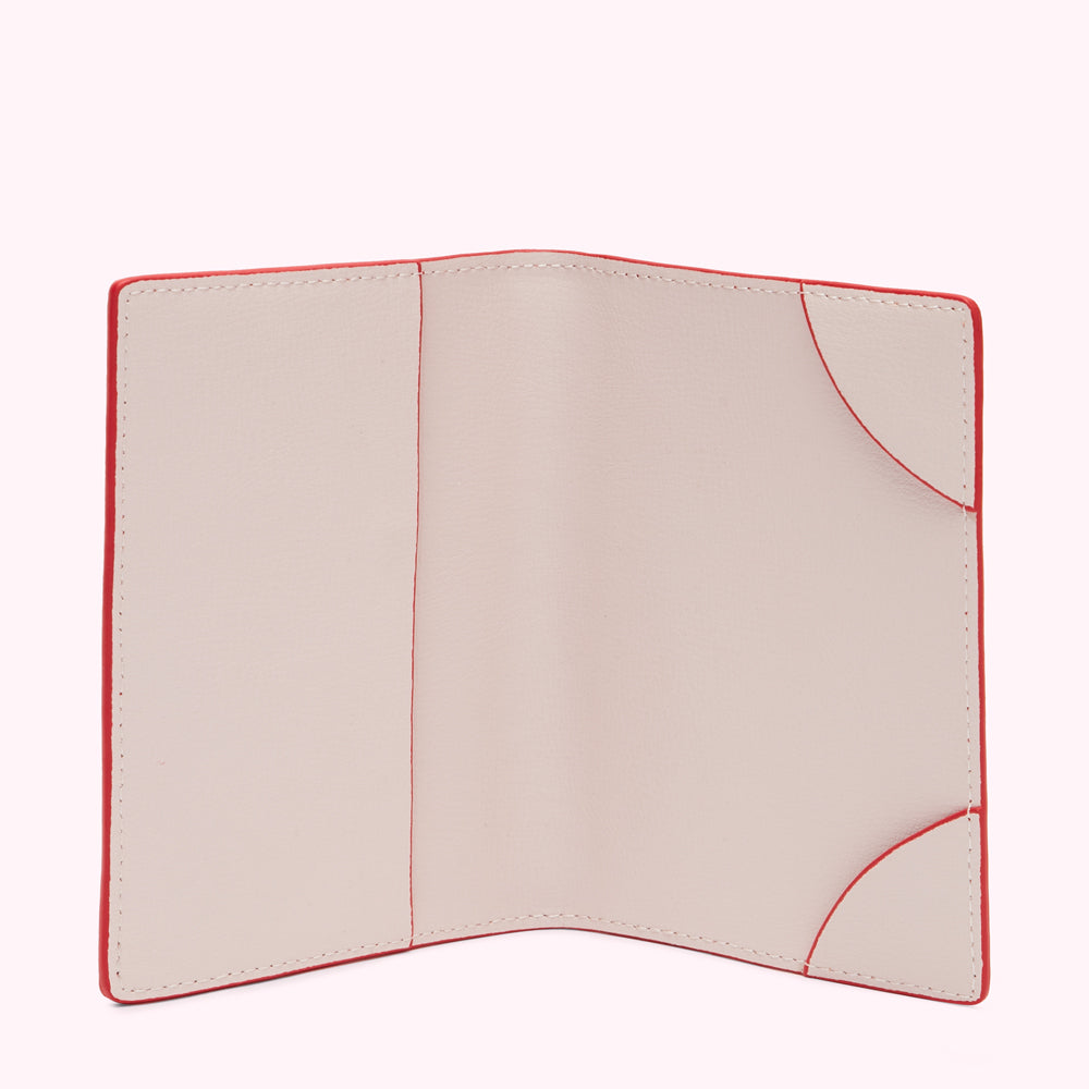 Red passport holder with beige interior open to show empty card slots.

