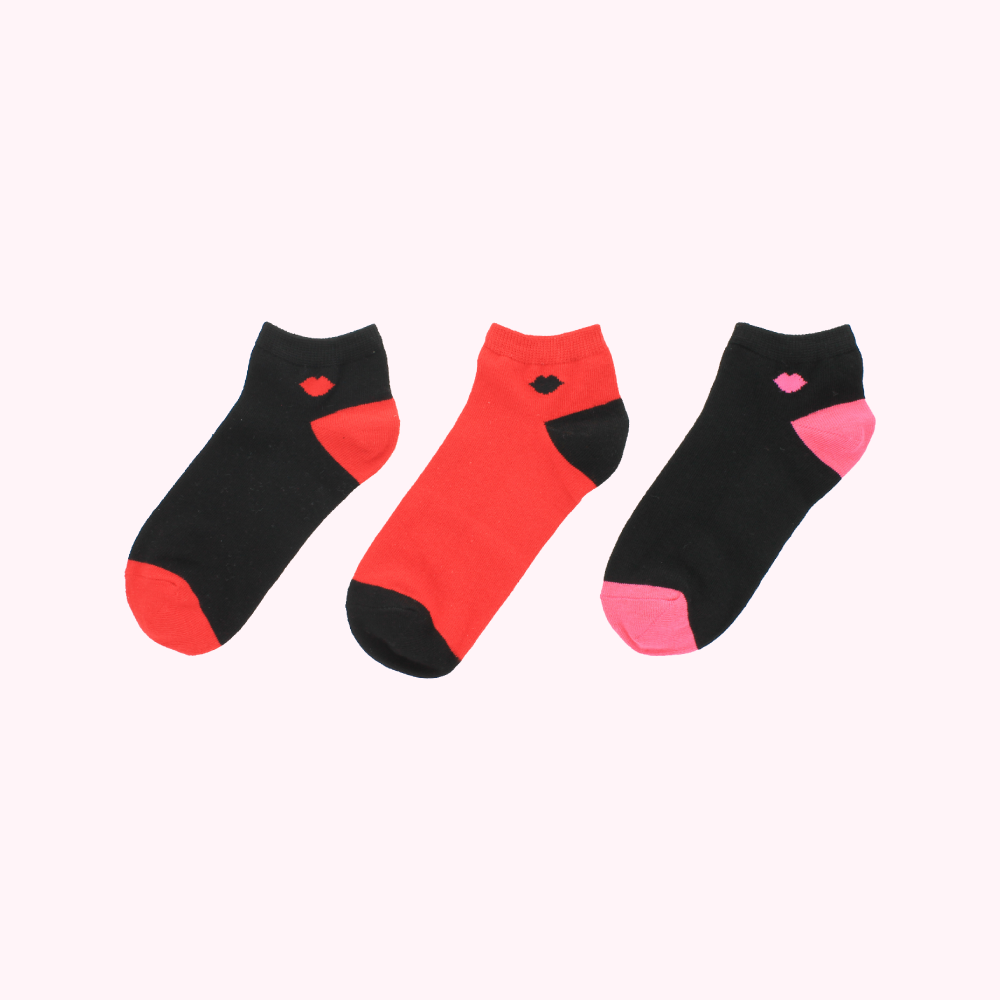 Three ankle socks with a lip design; one black with red heel and toe, one red with black heel and toe, and one black with pink heel and toe.
