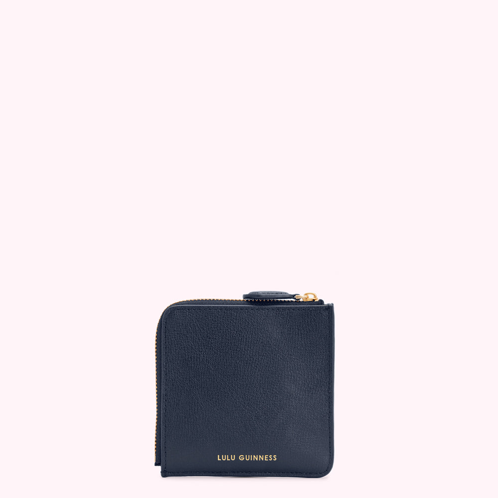 A navy blue Lulu Guinness zip-around wallet against a white background.
