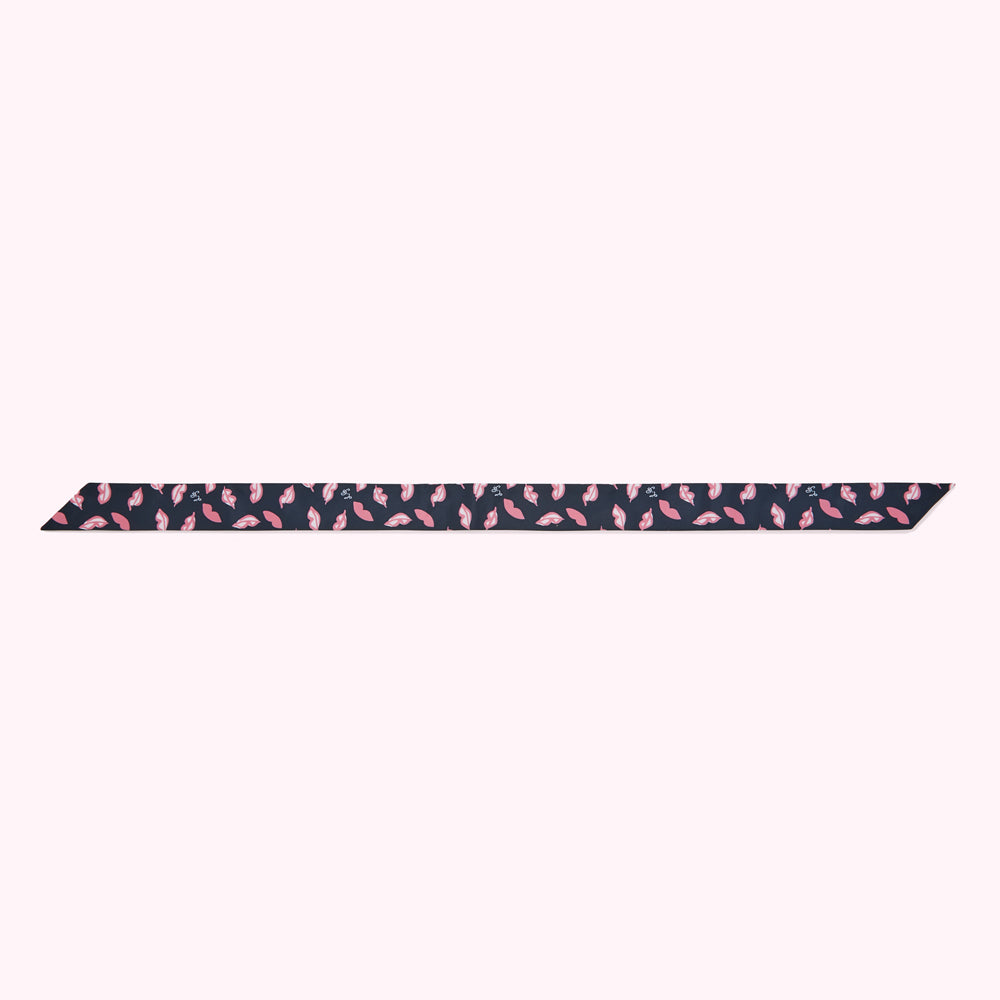 Dark navy blue ribbon with a repeating pattern of pink lips and small white flowers.