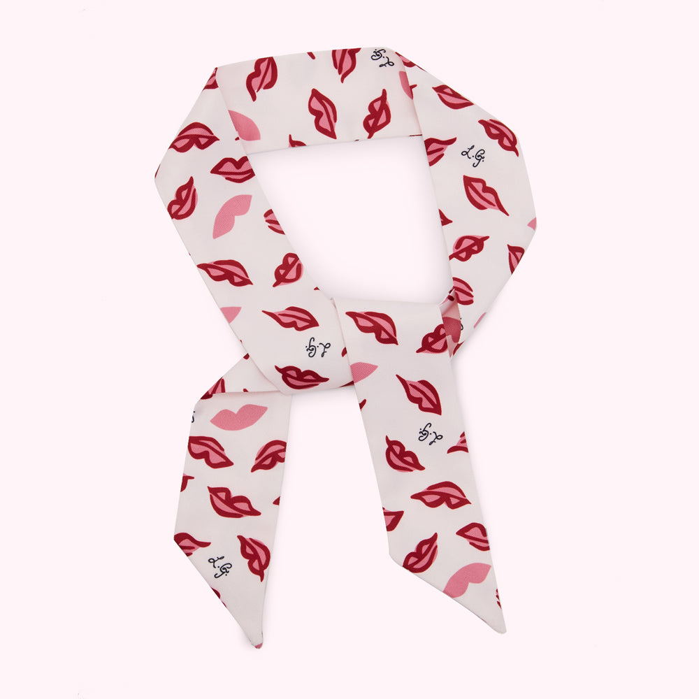 White silk scarf with a pattern of red lips and a logo.