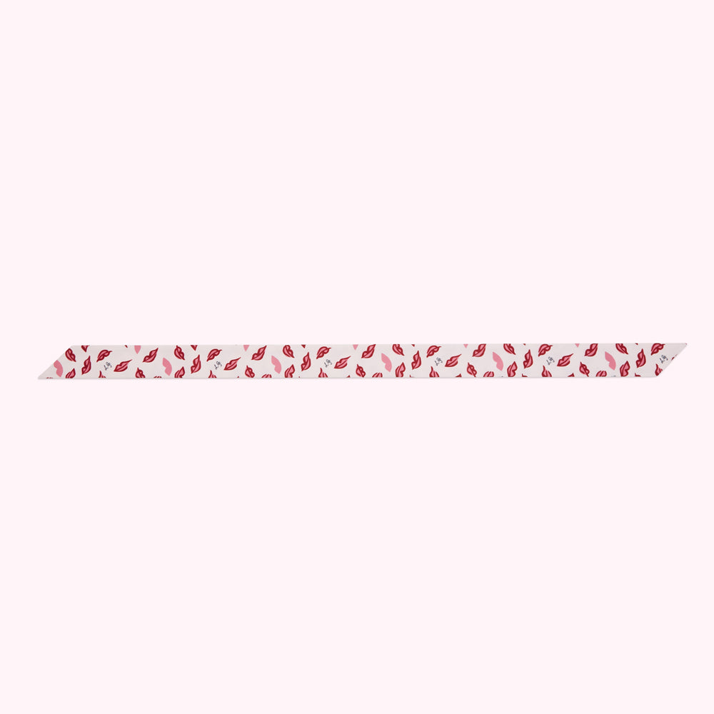 Off-white ribbon with a repeating pattern of red and pink lips.
