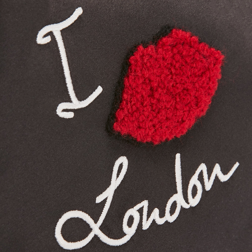 Black background with white embroidered text "I Love London," and a red embroidered lip shape in the center.
