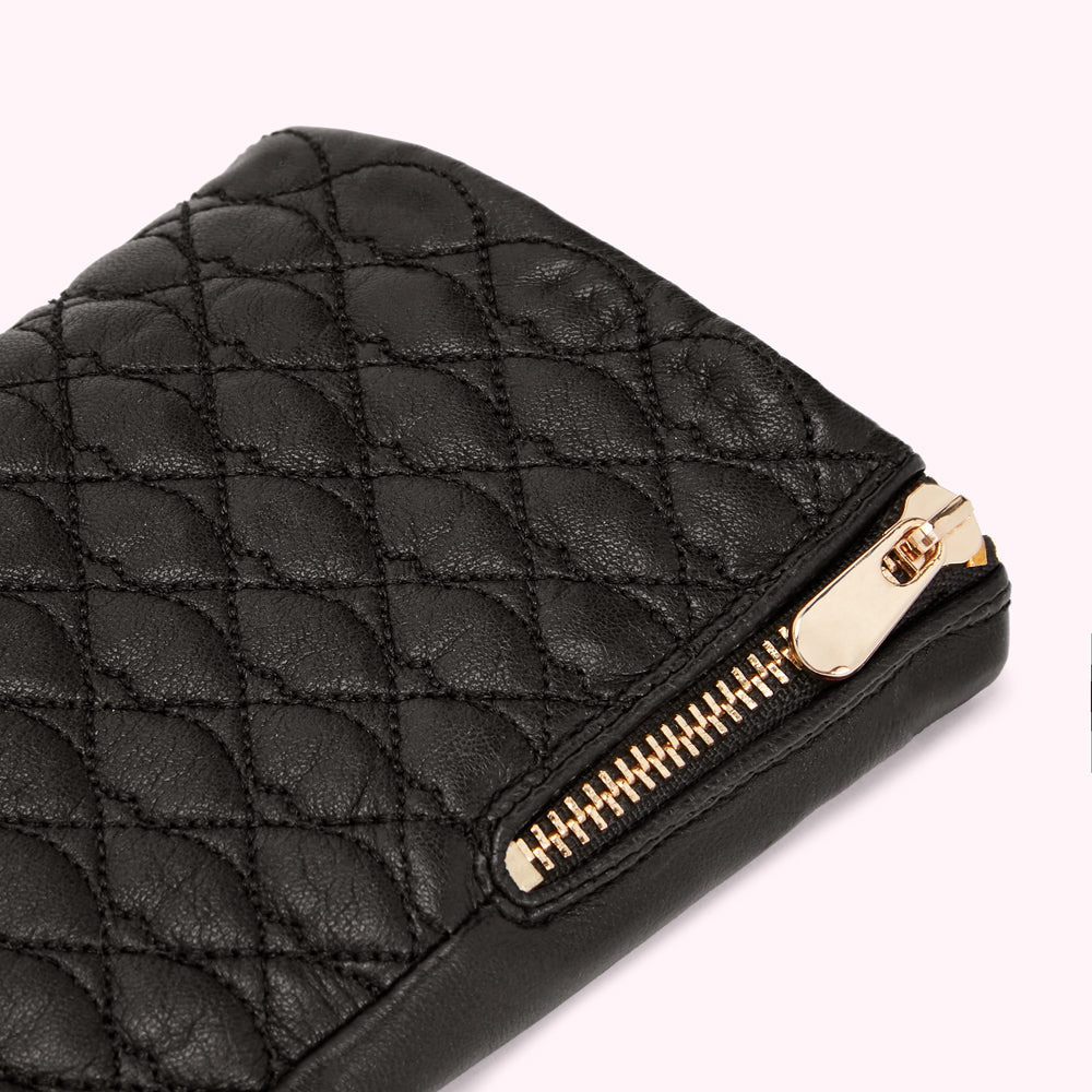 Close-up of a black quilted leather wallet with a gold zipper.
