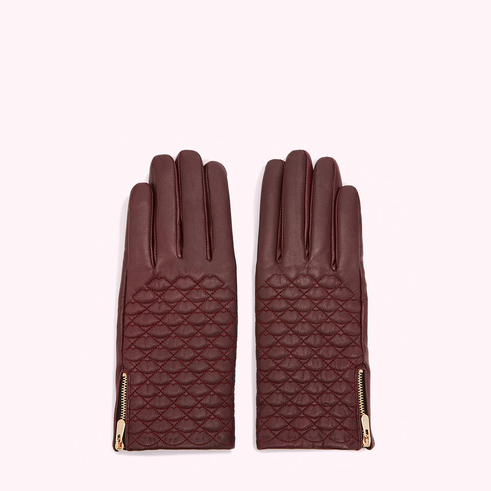 Pair of quilted burgundy leather gloves with gold zippers.

