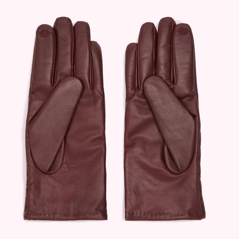 Pair of burgundy leather gloves on a white background.
